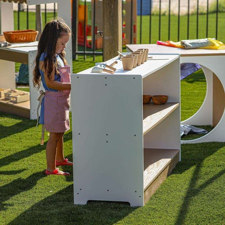 Child interacting with the outdoored storage for outdoor classrooms and preschool learning spaces
