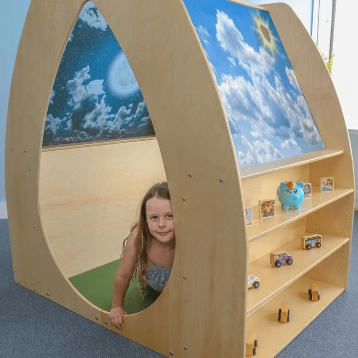 Child independently playing inside the Whitney Brothers Sky View Sanctuary, showing the comfortable interior with day sky acrylic panels visible above in the biophilic quiet space