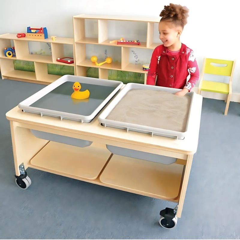 Child playing at the Whitney Brothers Whitney Plus Two Tub Sand & Water Table, showing the dual-tub sensory table with sand and water available simultaneously for hands-on classroom sensory play